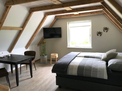 a bedroom with a bed and a table and a window at Lagune No1 in Büsum