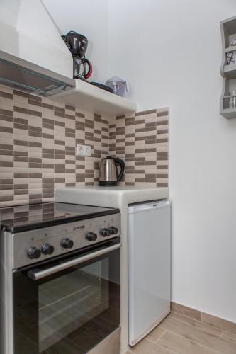 a kitchen with a stove and a refrigerator at Naxos Illusion Nikos Verikokos in Naxos Chora