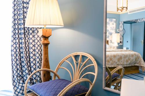 a room with a chair and a lamp and a mirror at The Albatroz Hotel in Cascais