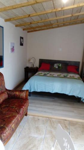 - une chambre avec un lit et un canapé dans l'établissement l'orchidée, à Talais