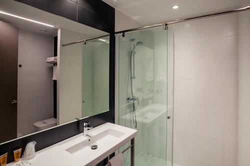 een badkamer met een wastafel en een glazen douche bij Tramuntana in La Jonquera