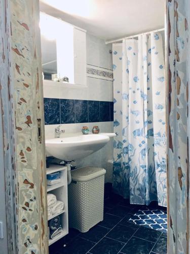 a bathroom with a sink and a shower curtain at Atlantida Spacious Flat in Fira