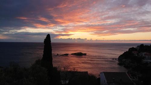 a sunset over the ocean with a rock in the water at Apartment Ulcinj in Ulcinj