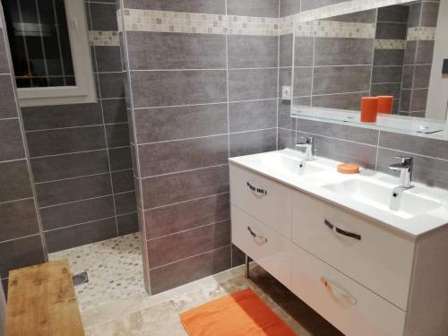 une salle de bain avec un lavabo blanc et un miroir dans l'établissement chez ma mie, à Théziers