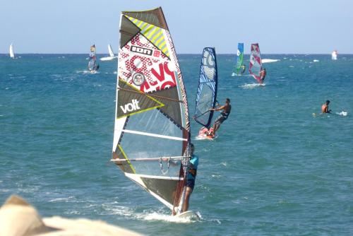 a group of people windsurfing in the ocean at Hotel Villa Taina in Cabarete