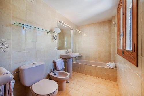 uma casa de banho com um WC, um lavatório e uma banheira em Apartment Ran de Mar em Port de Pollença