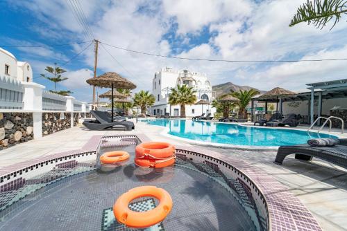 a swimming pool with orange inflatables in a resort at Black Coast Santorini in Perivolos