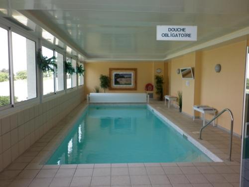 - une grande piscine dans un bâtiment dans l'établissement Résidence De La Corniche - vue sur mer, à Plestin-les-Grèves