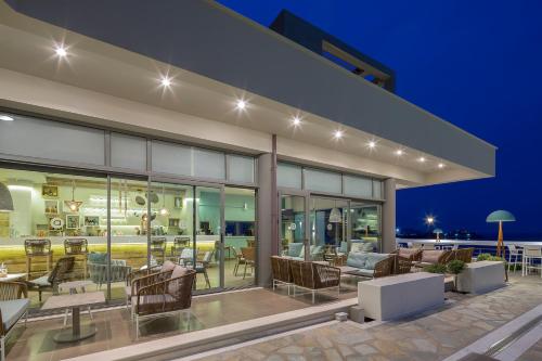 an outdoor patio with chairs and tables at night at Anastasia Hotel & Suites Mediterranean Comfort in Karistos