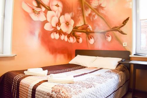 チェレポヴェツにあるАРТ-Отельのベッドルーム1室(花の絵が飾られたベッド1台付)