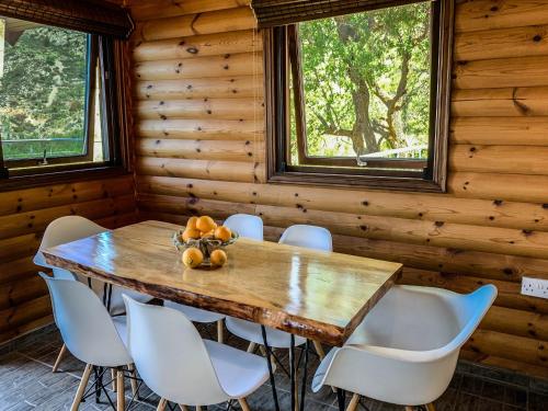 comedor con mesa de madera y sillas blancas en Vasiliou House Krimenos en Khandria