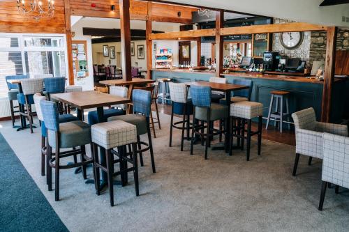 a restaurant with tables and chairs and a bar at Mendip Spring Golf and Country Club in Churchill