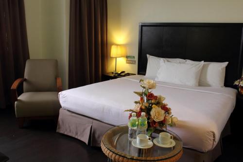 a hotel room with a bed and a table with flowers at Good Hope Hotel in Skudai