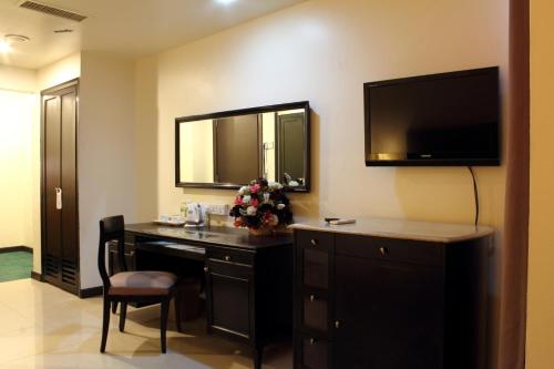 a hotel room with a desk and a television at Good Hope Hotel in Skudai