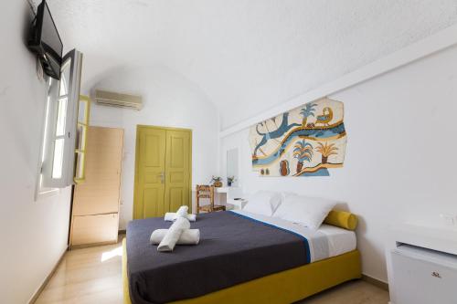 a bedroom with a bed and a painting on the wall at Sunny Days in Fira