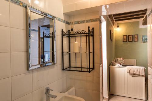ein Bad mit einem Waschbecken und einem Spiegel in der Unterkunft Ca' Montalcino in San Giovanni dʼAsso