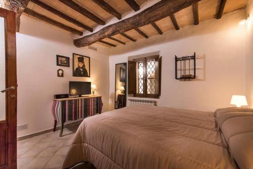 ein Schlafzimmer mit einem großen Bett in einem Zimmer in der Unterkunft Ca' Montalcino in San Giovanni dʼAsso