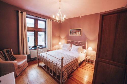 a bedroom with a bed and a chair and a window at Au Plaisir in Hastière-par-delà