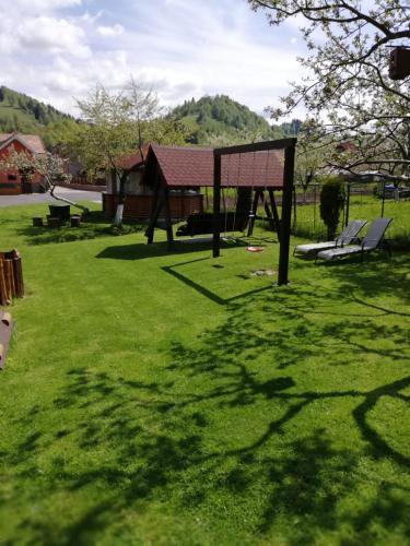 a park with a swing set in the grass at Pensiunea Denisa Stoian in Moieciu de Jos