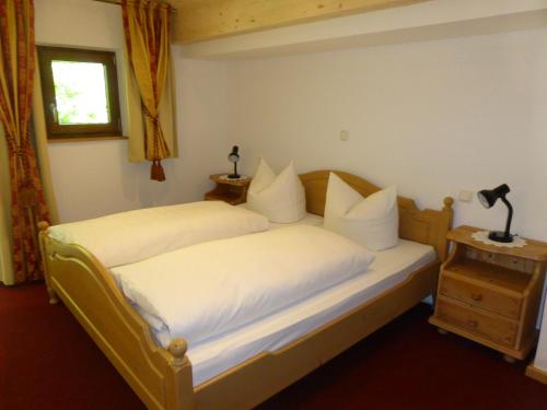 a bedroom with two beds with white sheets and a window at Gasthaus - Pension - Café Dörfl in Kiefersfelden