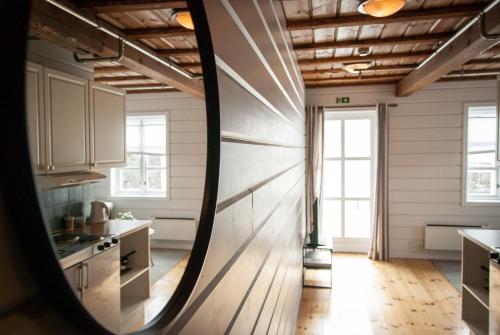 a kitchen with white walls and wooden floors and windows at Lødingen Brygge in Lødingen