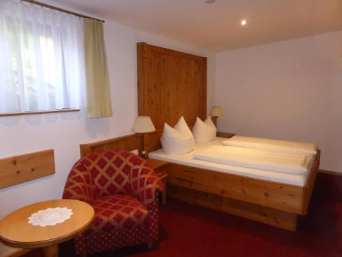 a small bedroom with a bed and a chair at Gasthaus - Pension - Café Dörfl in Kiefersfelden