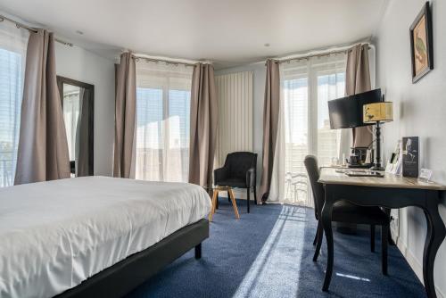 um quarto de hotel com uma cama, uma secretária e janelas em Hotel Le Berry em Saint-Nazaire