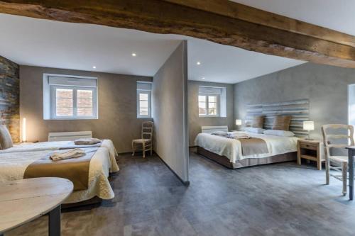 a bedroom with two beds and a table and chairs at Les 3 cépages in Balnot-sur-Laignes