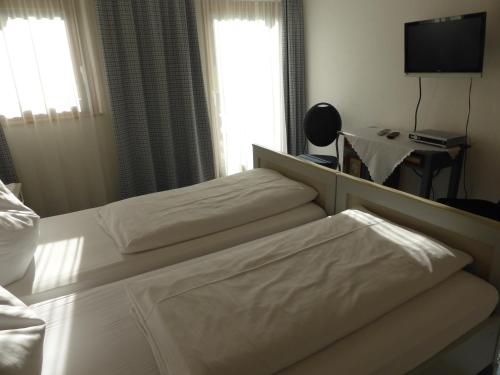 a hotel room with two beds and a television at Gasthaus - Pension - Café Dörfl in Kiefersfelden