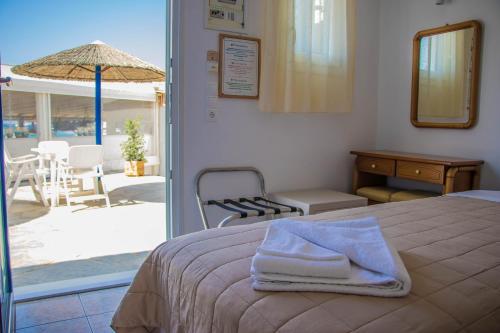 a bedroom with a bed and a patio with an umbrella at Romantika in Platis Gialos