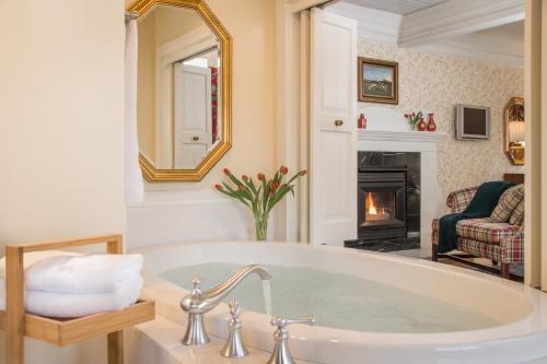 a bath tub in a bathroom with a fireplace at The INN at Ormsby Hill in Manchester