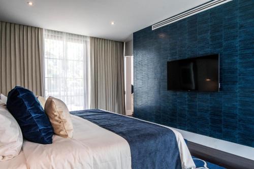 a bedroom with a bed and a tv on a wall at Marsella 45 in Hermosillo