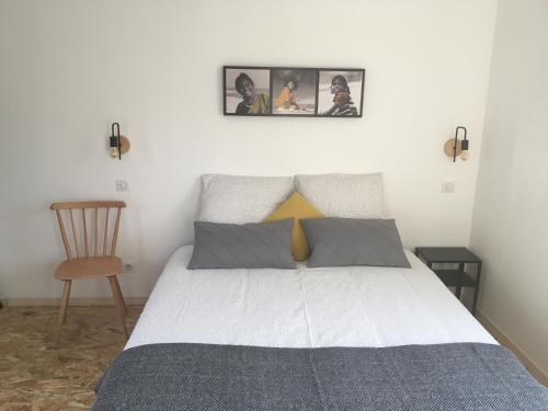 a bedroom with a bed with two pictures on the wall at Les Terrasses du Donon in Raon-lès-Leau
