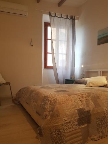 a bedroom with a bed and a window at Appartamento il Riccio in Portoferraio