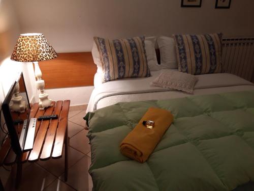 シルミオーネにあるDebora Maison B&Bのベッドルーム1室(ベッド1台、ランプ付きテーブル付)