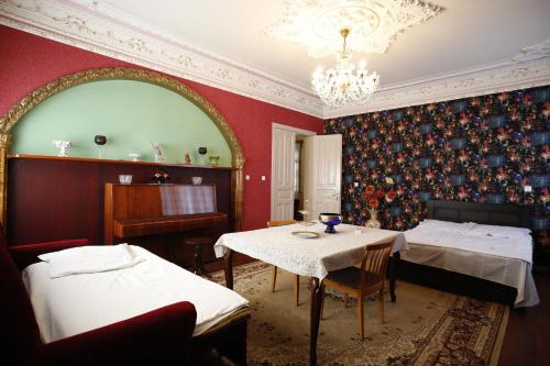a room with two beds and a table and a piano at Nature House in Kutaisi