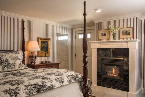 a bedroom with a bed and a fireplace at The INN at Ormsby Hill in Manchester
