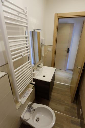 a bathroom with a sink and a toilet and a mirror at Le Coccole in La Spezia