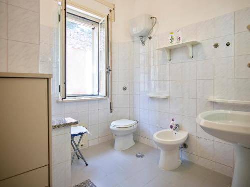 a white bathroom with a toilet and a sink at Solerosa in Fondi
