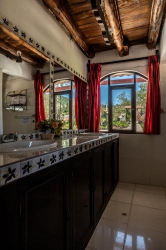 a kitchen with a sink and red curtains at Hotel Villa de Paris in Chachapoyas