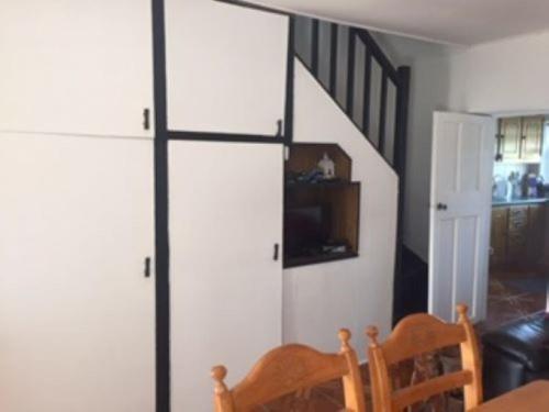 een woonkamer met een schuifdeur en een trap bij Maisie's Seaside Cottage in Quilty