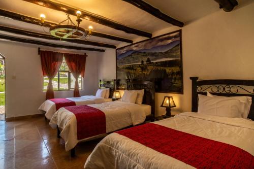 a bedroom with two beds and a painting on the wall at Hotel Villa de Paris in Chachapoyas