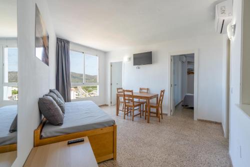 1 dormitorio con 1 cama y 1 mesa con sillas en Magalluf Playa Apartments - Adults Only, en Magaluf