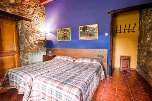 a bedroom with a bed in a room with purple walls at Can Cisquet in El Pla de Teyá