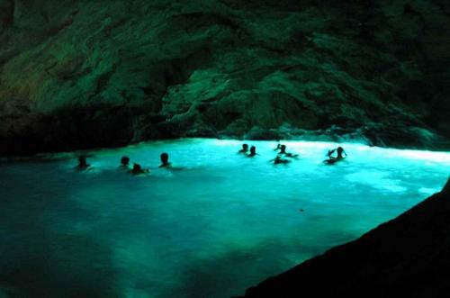 a group of people swimming in a blue cave at VILLE GIRASOLI "VILLA NELLA BAIA" with PRIVATE SWIMMING POOL in Tricase