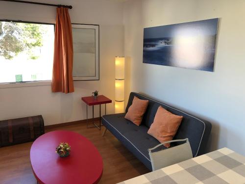 a living room with a couch and a table at Llevant 11 E1 in Cala en Bosc