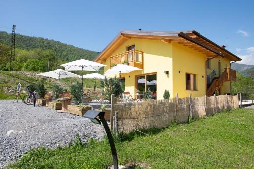 a yellow house with umbrellas in front of it at Agriturismo La Soglia Del Parco in Ranica