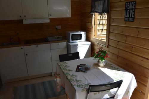 a small kitchen with a table and a microwave at FAXESTUGORNA in Abbekås