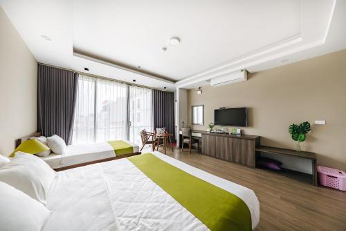 a hotel room with two beds and a flat screen tv at Hana 2 Apartment & Hotel Bac Ninh in Bắc Ninh
