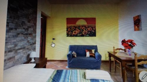 sala de estar con silla azul y mesa en Girasole en Terrasini Favarotta